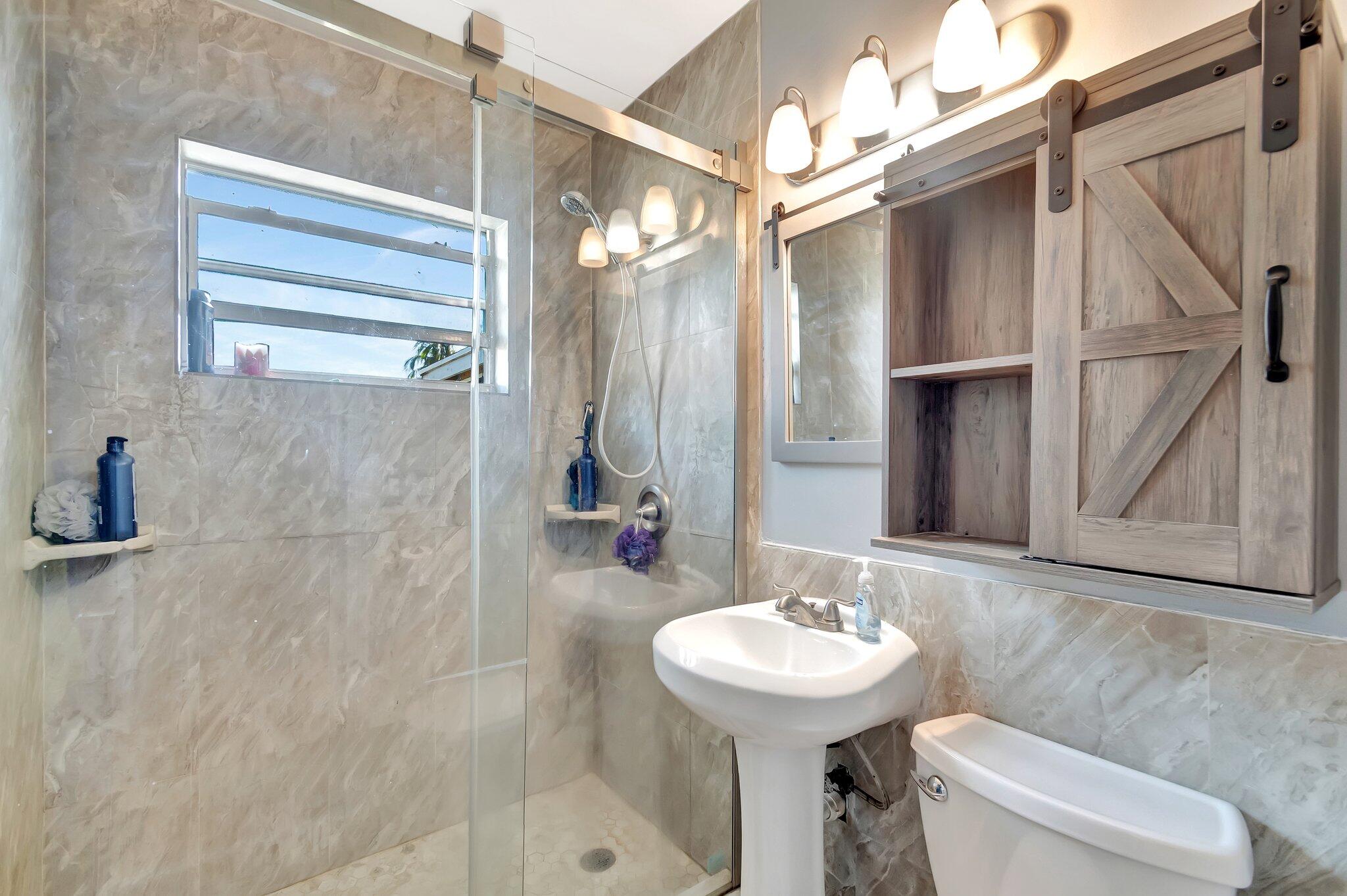 3890 Ocala Road Lake Worth, FL 33462 - Photo 15 of 29 a bathroom with a sink a toilet a mirror and shower