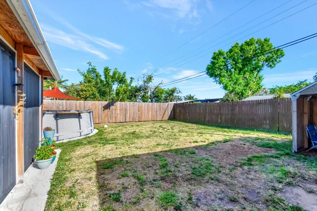 a backyard with a fence and some plants