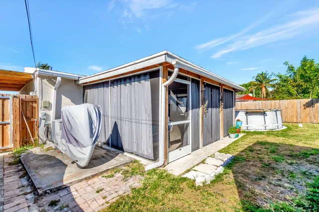 a view of a backyard with chairs and a grill