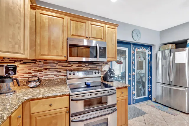 a kitchen with granite countertop a stove and a refrigerator