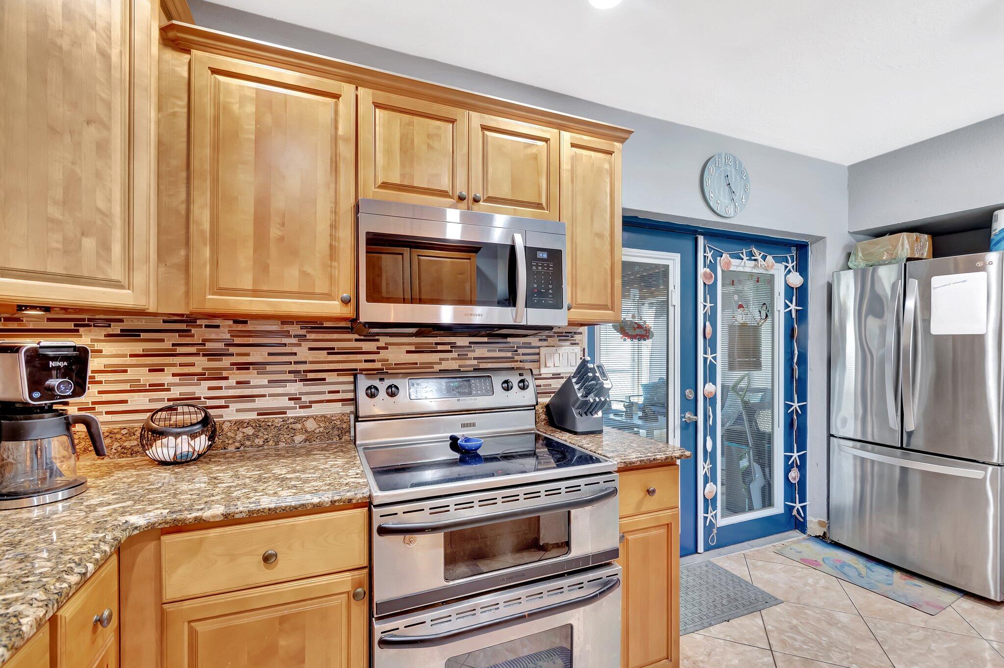3890 Ocala Road Lake Worth, FL 33462 - Photo 9 of 29 a kitchen with granite countertop a stove and a refrigerator