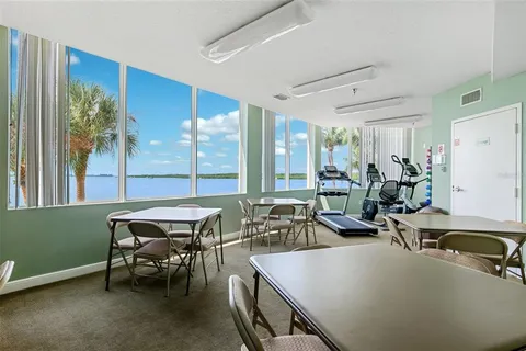 a dining room with furniture and a floor to ceiling window