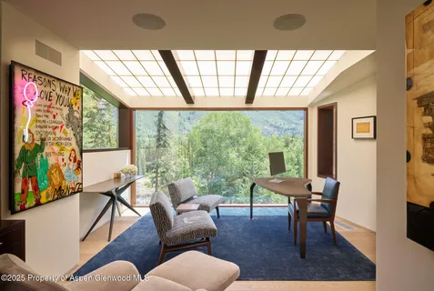 a living room with furniture and a floor to ceiling window