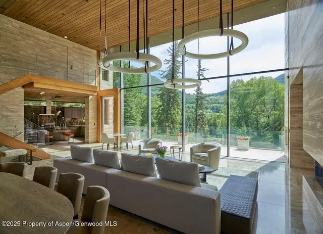 a living room with furniture a floor to ceiling window and a floor to ceiling window