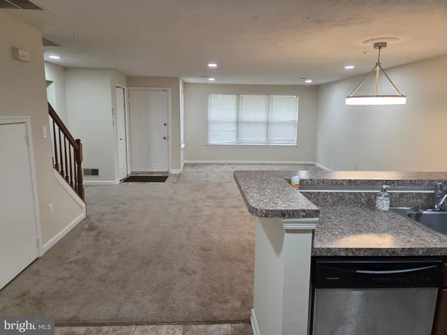 a view of a kitchen with granite countertop a sink and a stove