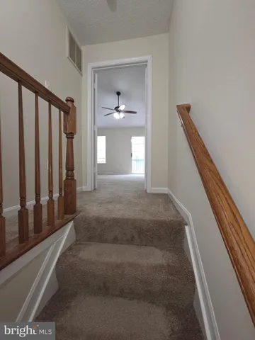 en empty room with windows and chandelier fan