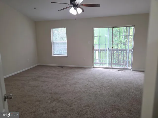a view of an empty room with a ceiling fan