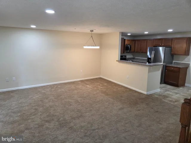 a view of kitchen with stainless steel appliances with kitchen island in it