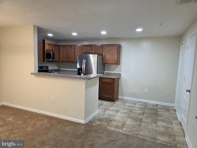 a view of kitchen with stainless steel appliances a sink and a refrigerator