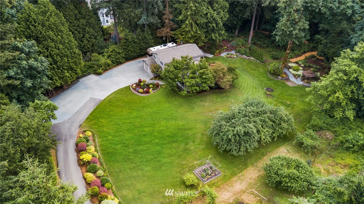 22303 49th Avenue Southeast Bothell, WA 98021 - Photo 2 of 25 an aerial view of a house with a yard lake and trees all around