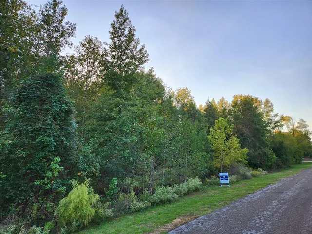 a view of a lake with a yard and large trees