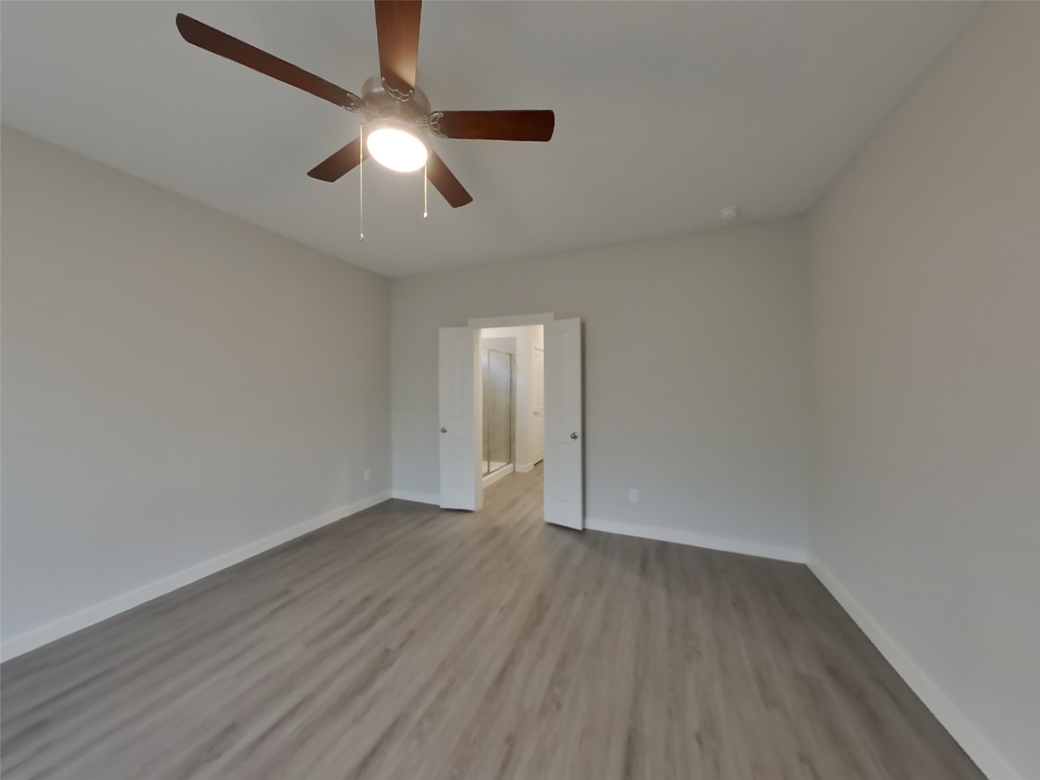 2407 Foster Hl Road Richmond, TX 77469 - Photo 7 of 24 an empty room with wooden floor chandelier fan and windows