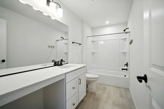 a bathroom with a sink a toilet a mirror and shower