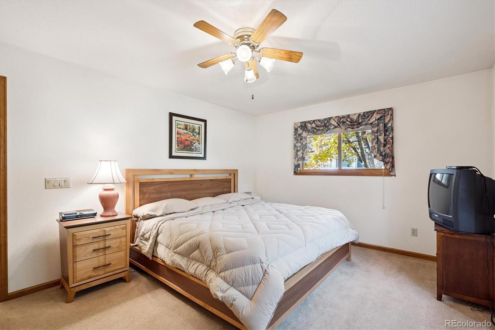 17537 59th Place Golden, CO 80403 - Photo 18 of 45 a bedroom with a bed and a chandelier