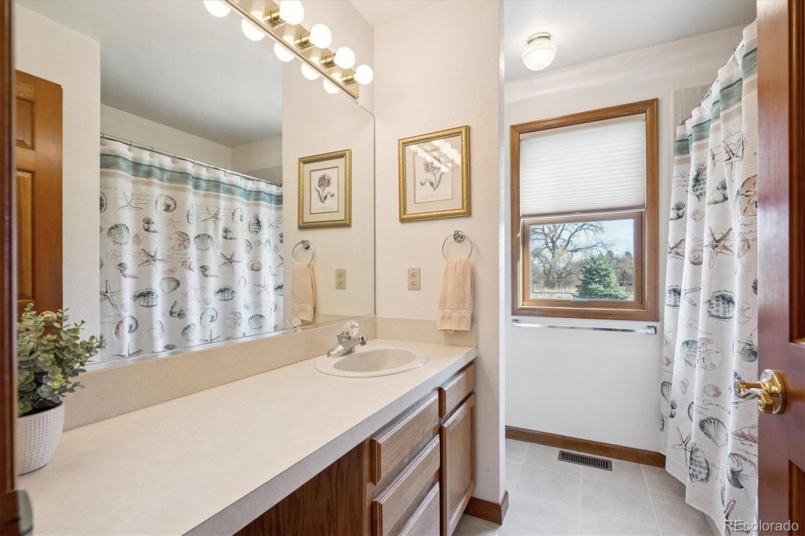 17537 59th Place Golden, CO 80403 - Photo 24 of 45 a bathroom with a sink a vanity and a mirror