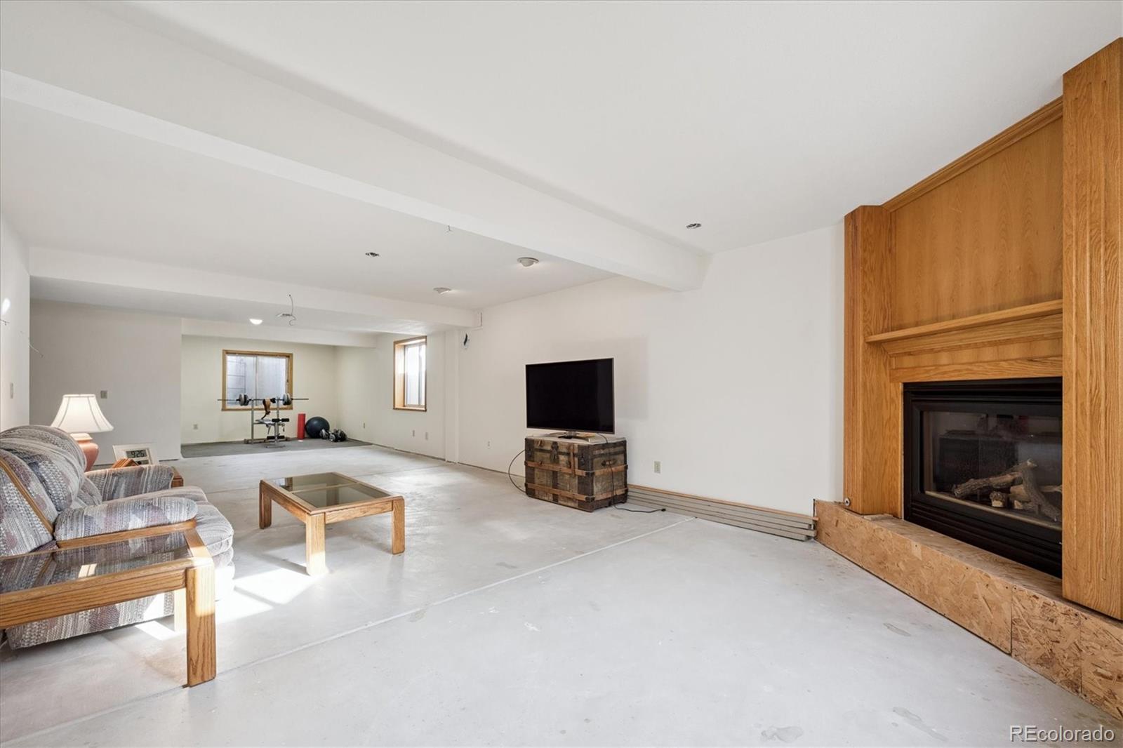 17537 59th Place Golden, CO 80403 - Photo 27 of 45 a living room with furniture a fireplace and a flat screen tv