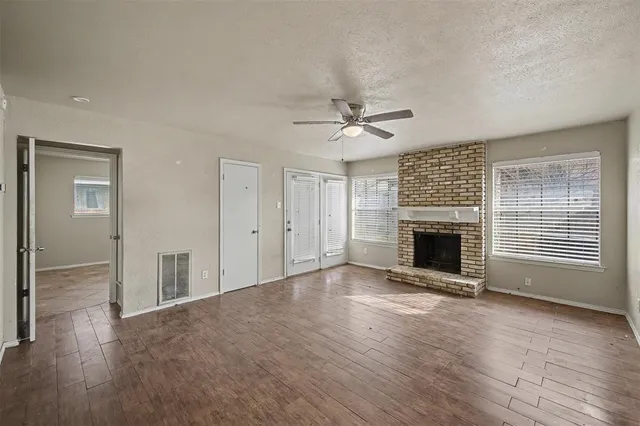 a view of an empty room with a fireplace and a window