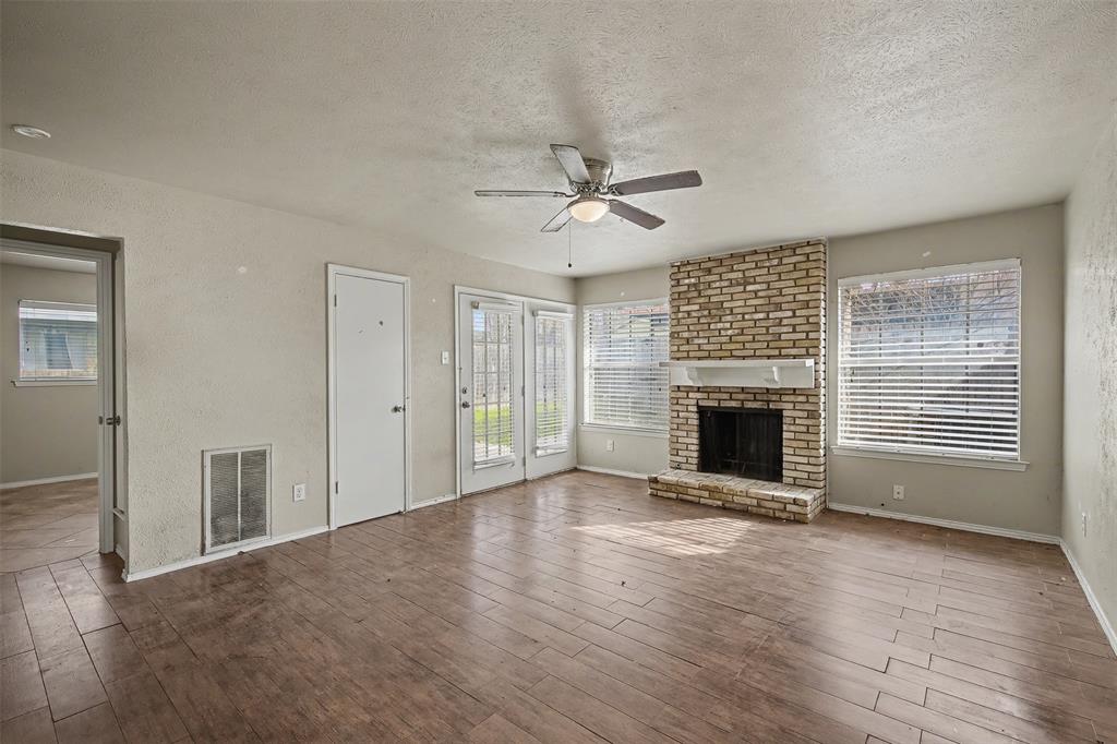 2302 18th Street Plano, TX 75074 - Photo 12 of 31 a view of a livingroom with a fireplace a ceiling fan and windows