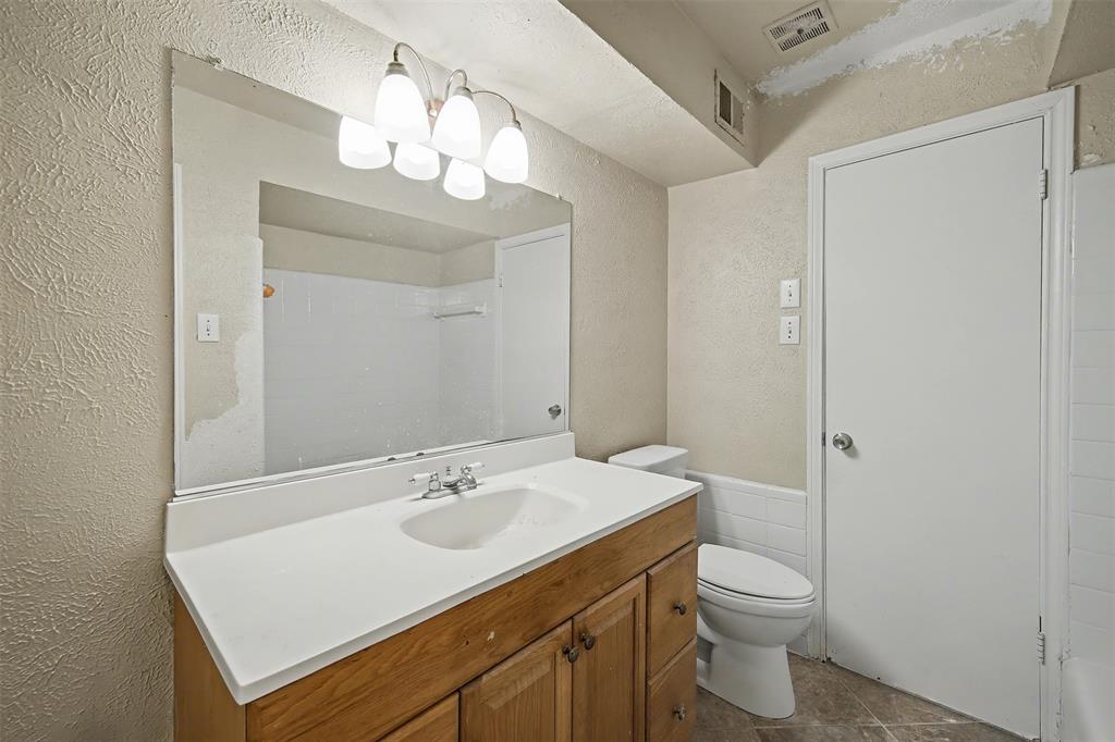 2302 18th Street Plano, TX 75074 - Photo 16 of 31 a bathroom with a sink a toilet and a mirror