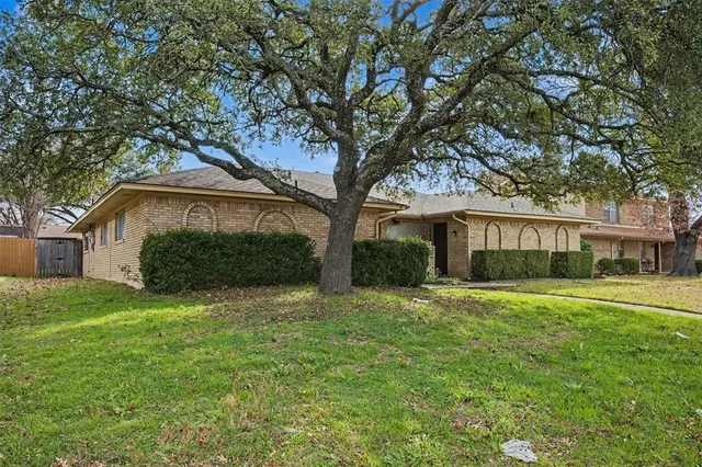 a front view of a house with a yard and trees