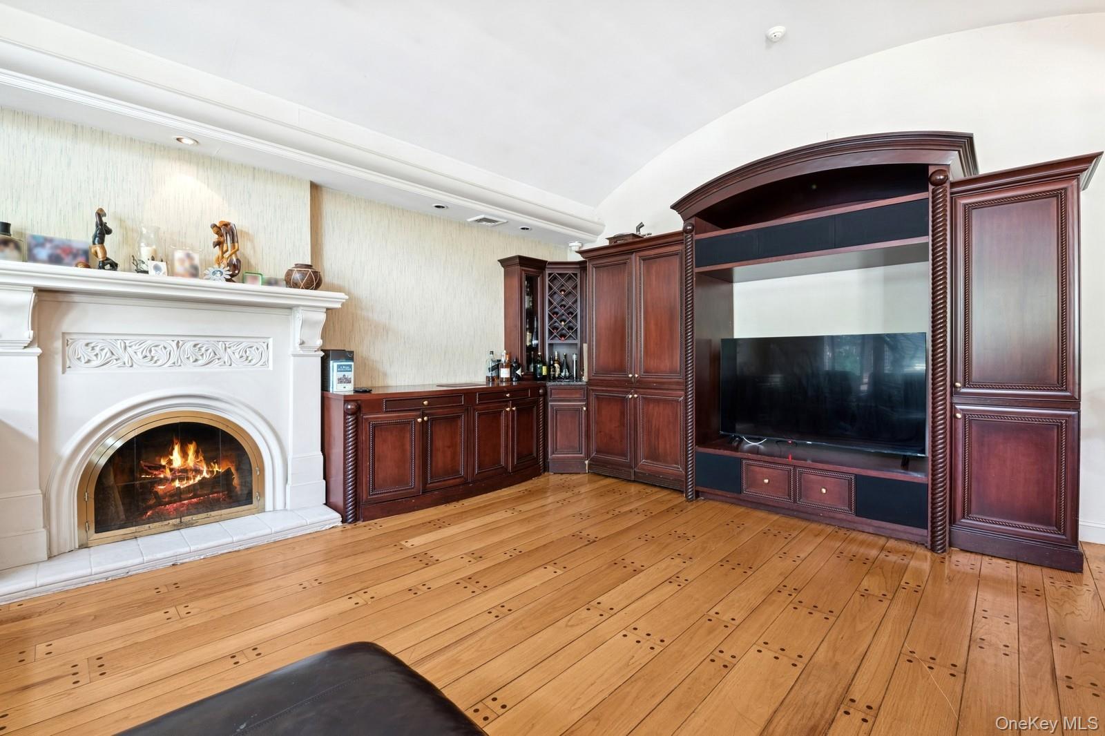 328 Ivy Hill Road Woodmere, NY 11598 - Photo 17 of 37 a living room with a fireplace and a flat screen tv