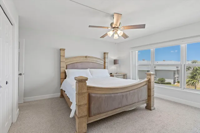 a spacious bedroom with a bed and a chandelier