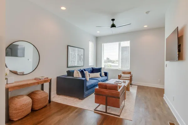 a living room with furniture a window and wooden floor