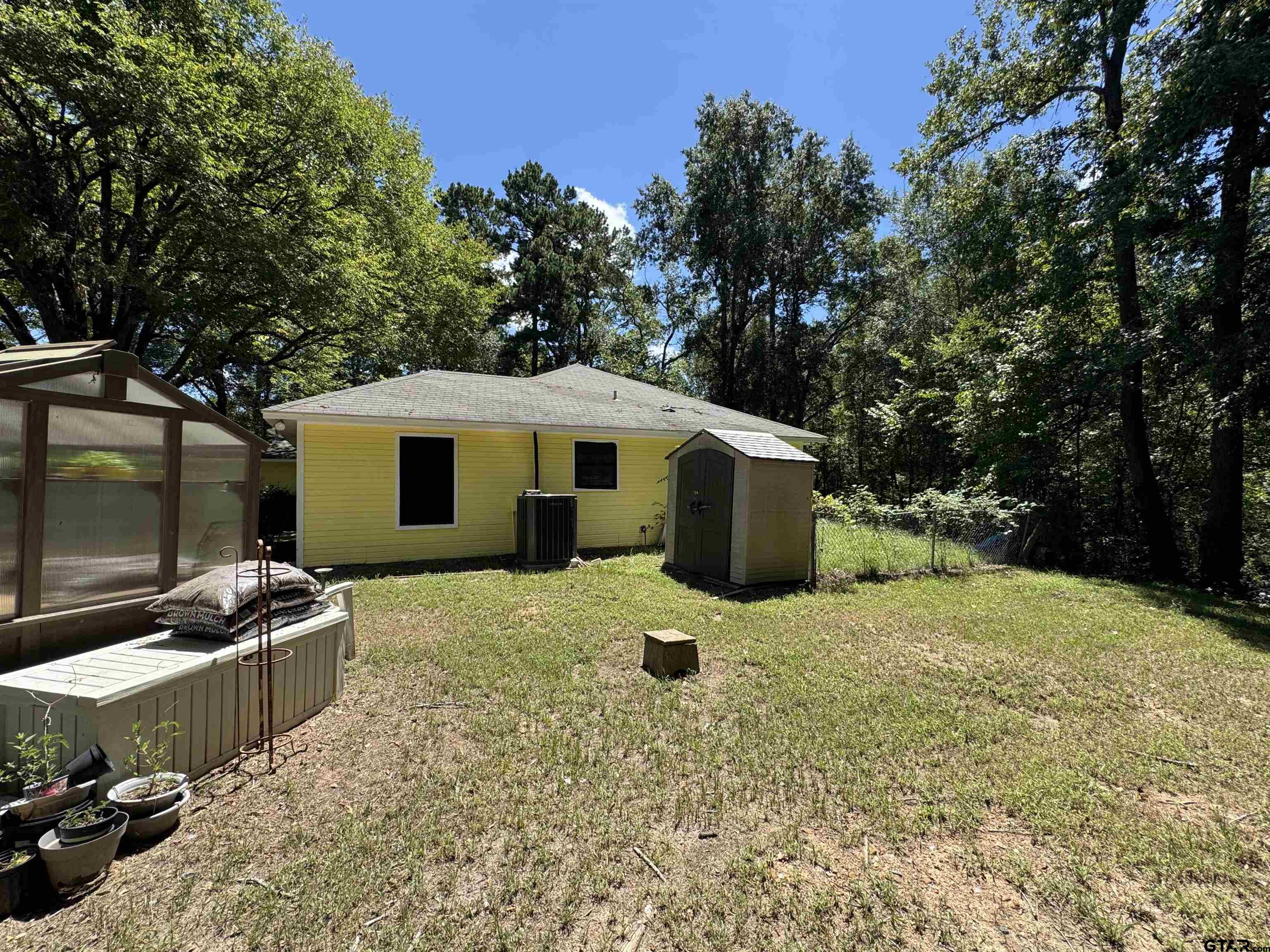 4159 Scrub Pine Road Gilmer, TX 75645 - Photo 12 of 39 a backyard of a house with barbeque oven and outdoor seating