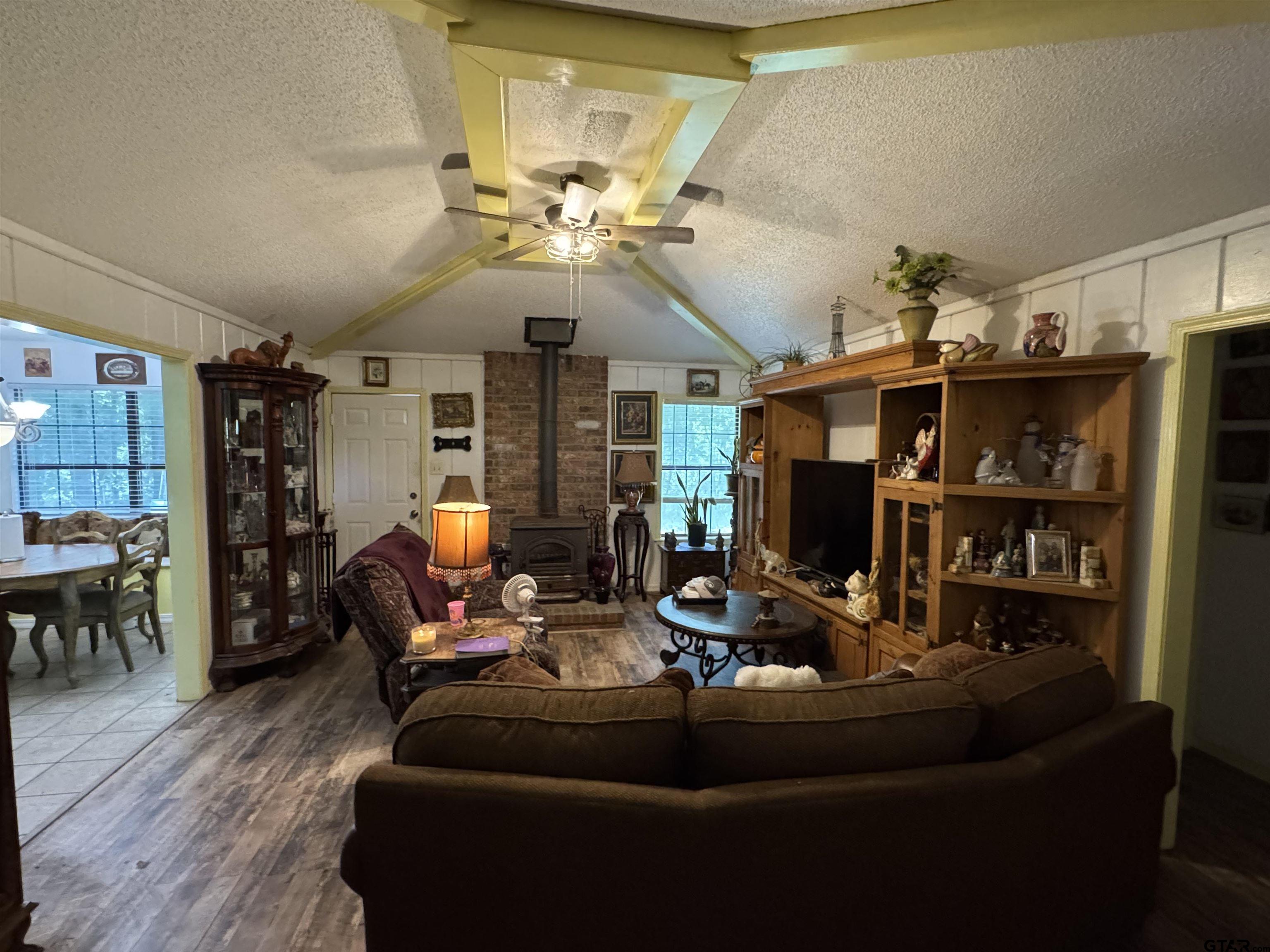 4159 Scrub Pine Road Gilmer, TX 75645 - Photo 16 of 39 a living room with furniture a dining table and a chandelier