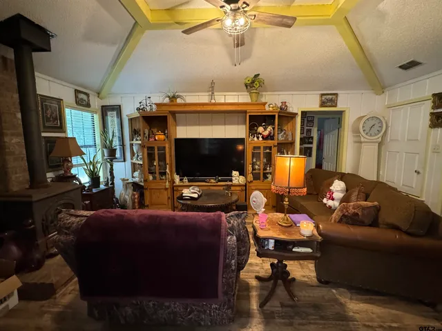 a living room with furniture a flat screen tv and a window
