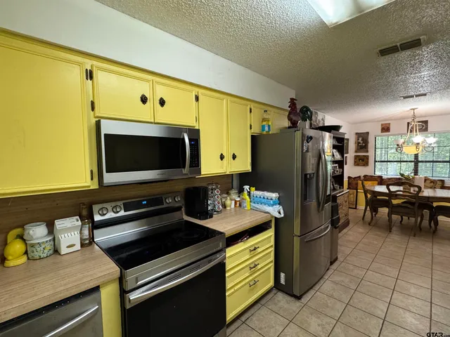 a kitchen with refrigerator and chairs