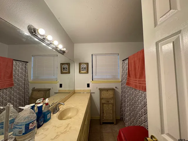 a bathroom with a tub sink and mirror