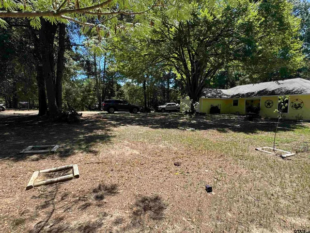 a backyard of a house with barbeque oven and trees