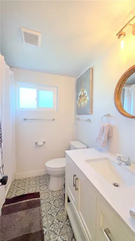 a bathroom with a sink a toilet and a mirror
