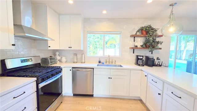 a kitchen with kitchen island granite countertop a sink cabinets window and stainless steel appliances
