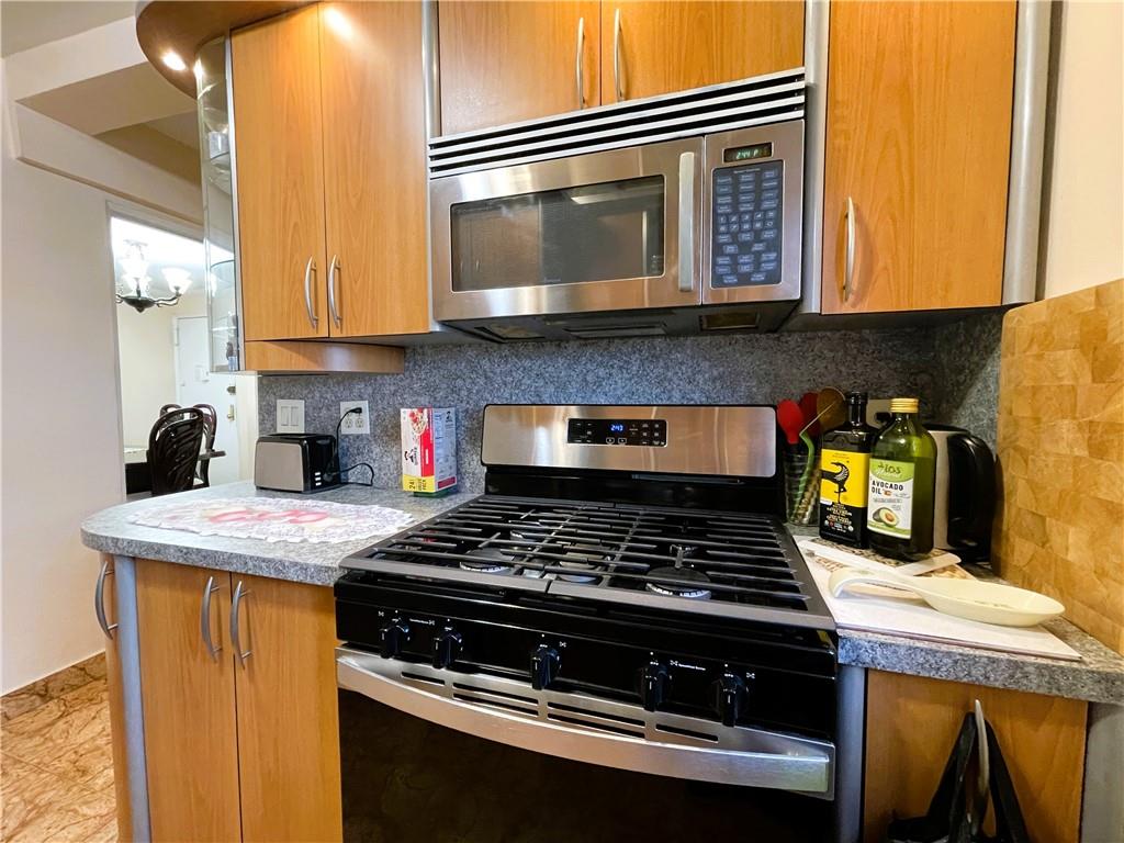 2711 Avenue X, Unit 6J Brooklyn, NY 11235 - Photo 12 of 24 a kitchen with stainless steel appliances granite countertop a stove and a microwave