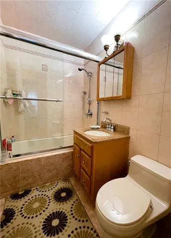 a bathroom with a granite countertop toilet sink and mirror