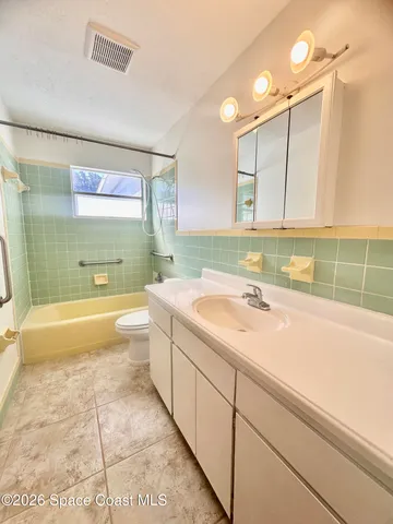 an empty room with a chandelier fan and windows