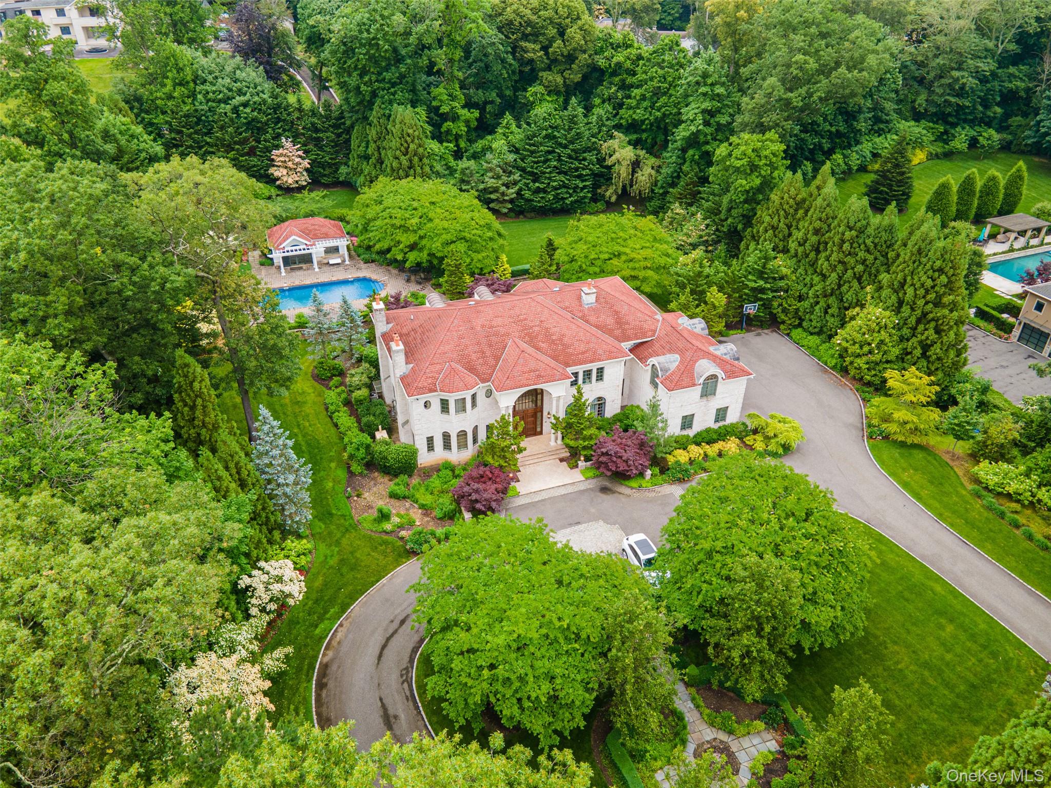 an aerial view of residential houses with outdoor space and trees all around