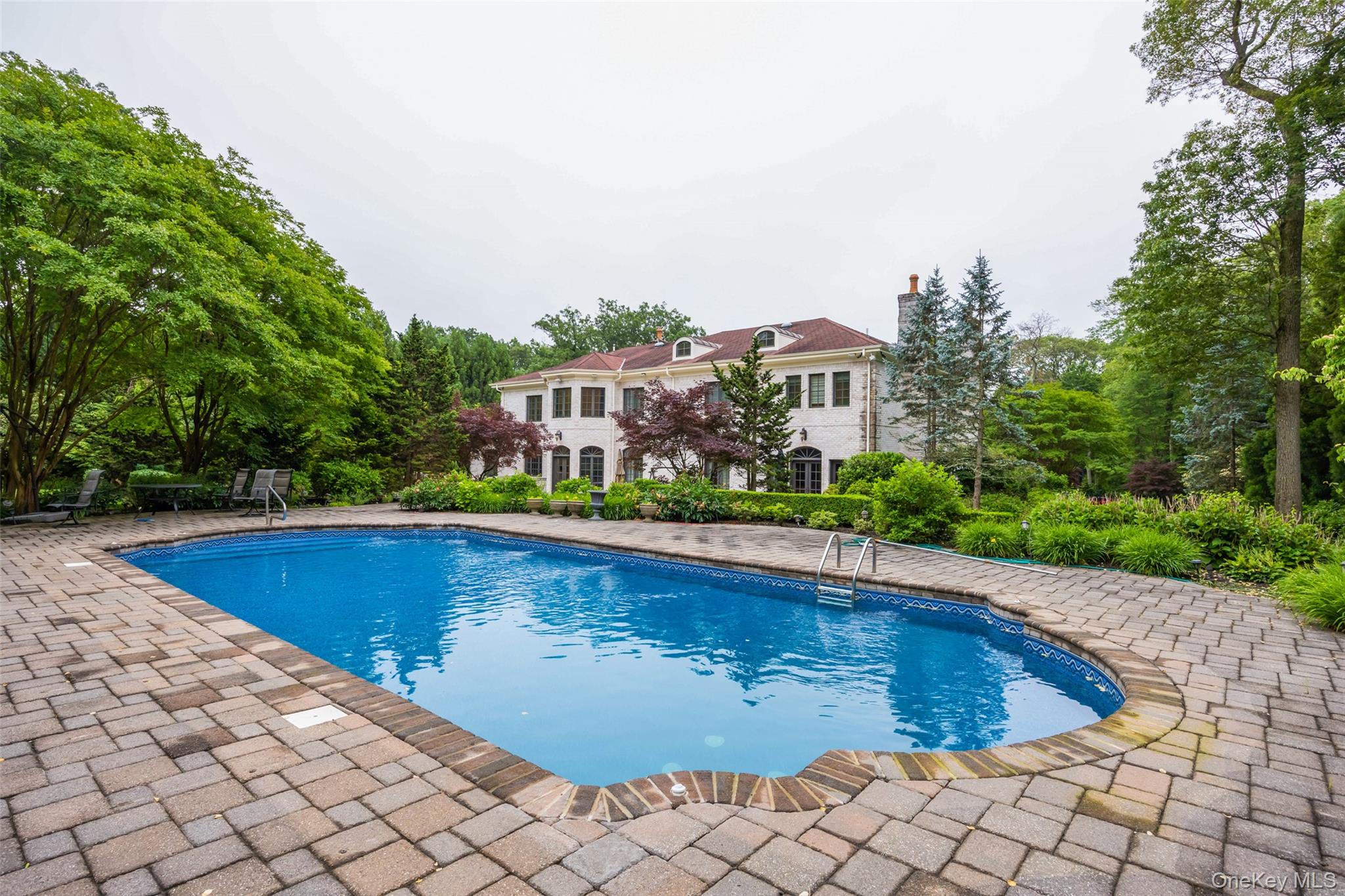 11 Black Rock Road Muttontown, NY 11545 - Photo 43 of 45 a view of swimming pool with outdoor seating and trees in the background