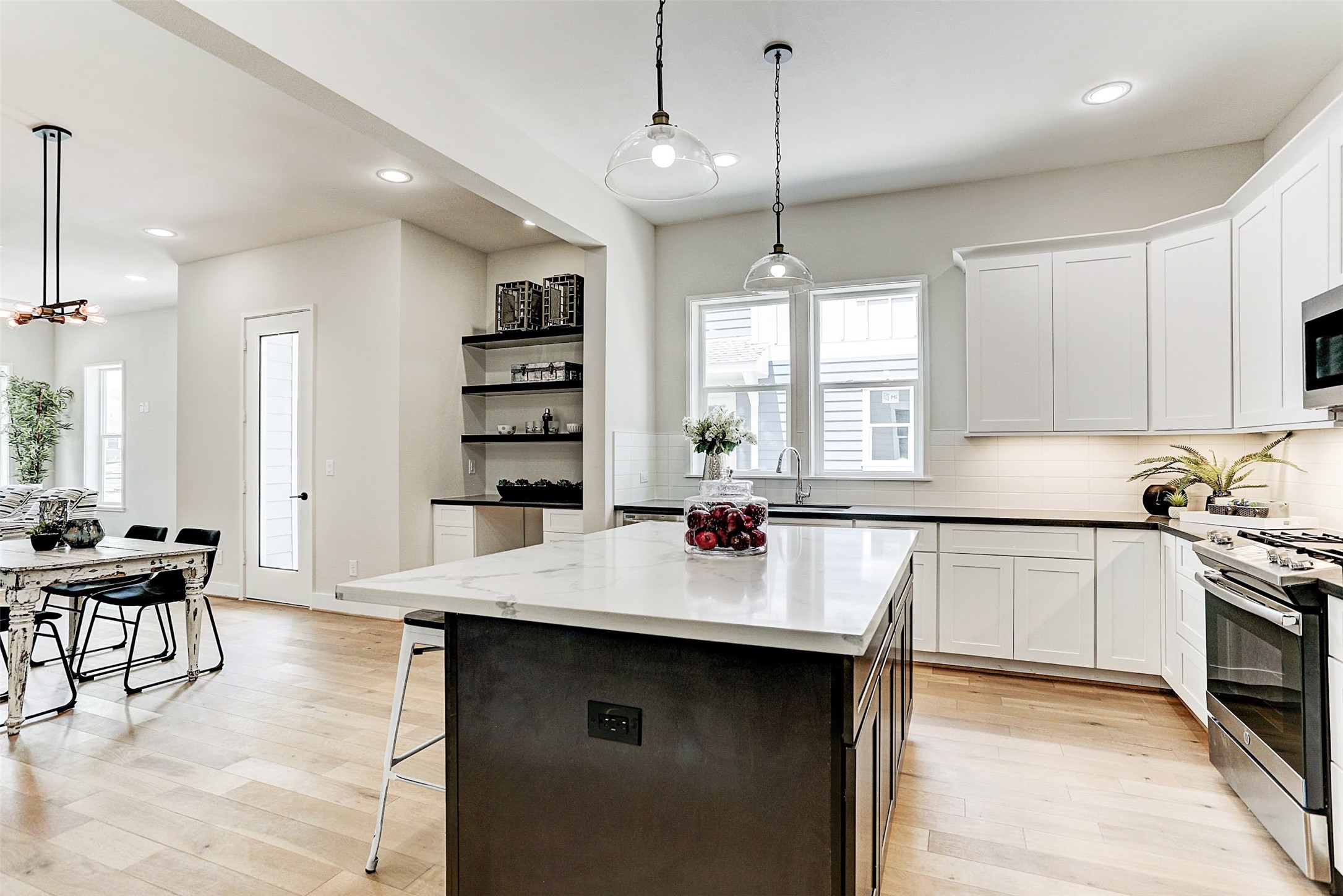 1115 West 15th 1/2 Street, Unit A Houston, TX 77008 - Photo 10 of 20 a kitchen with a stove a refrigerator and a dining table with wooden floor
