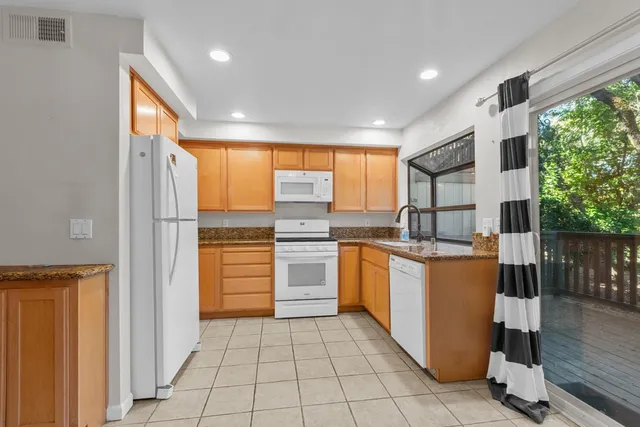 a kitchen with stainless steel appliances granite countertop a refrigerator and a sink