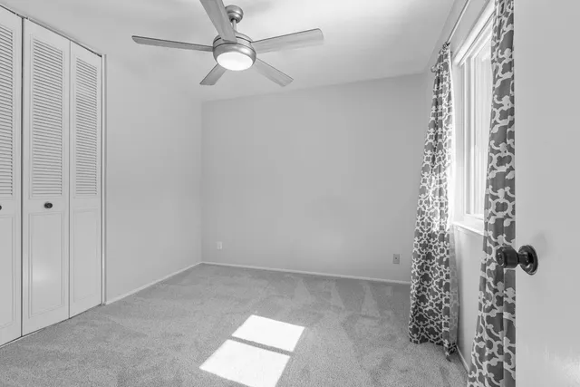 a view of room with a ceiling fan and a window