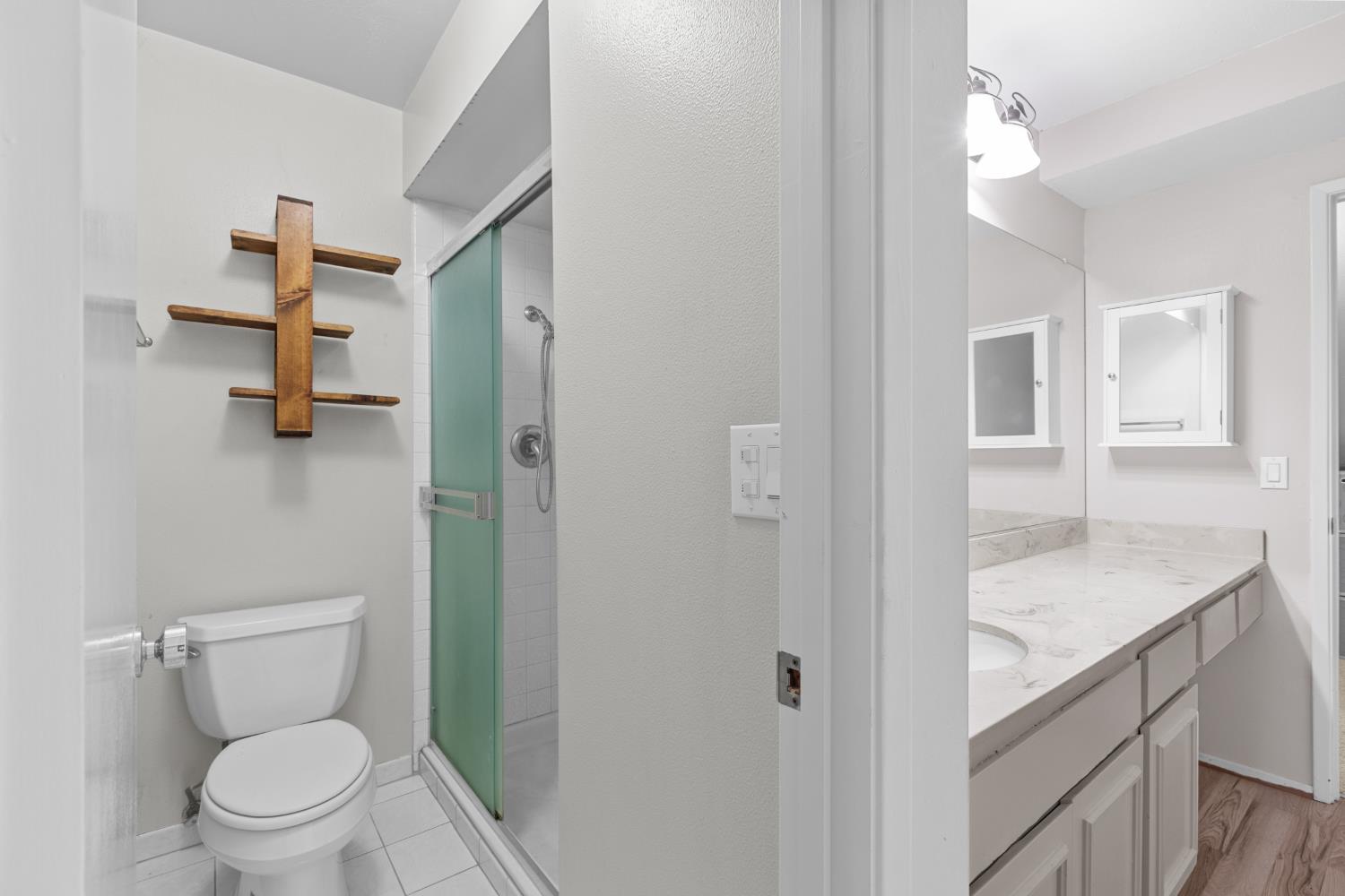 6909 Monticello Court Citrus Heights, CA 95621 - Photo 26 of 38 a bathroom with a granite countertop toilet a sink and a mirror