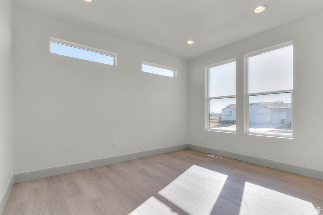 562 West Coyote Rdg Road Grantsville, UT 84029 - Photo 8 of 27 Room featuring wood-finish flooring, two large vertical windows, two horizontal transom windows, recessed lighting, and light gray baseboards