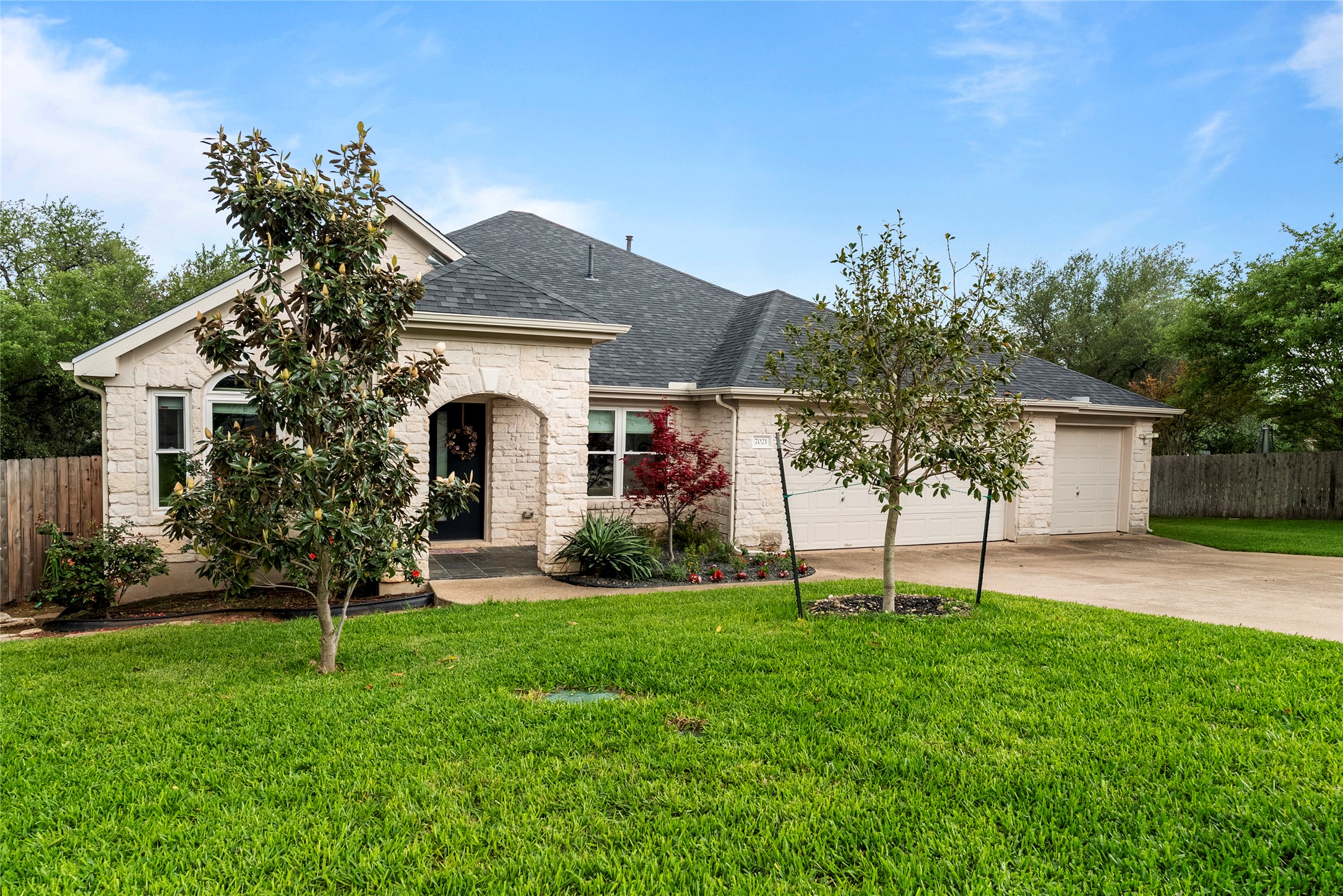 7021 Colberg Court Austin, TX 78749 - Photo 3 of 37 a front view of a house with a garden and trees