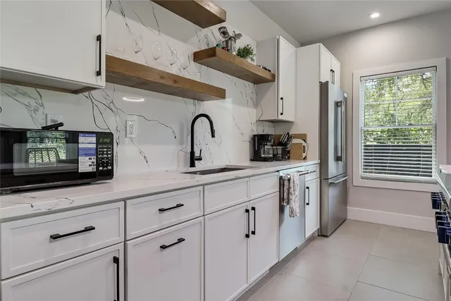 a kitchen with stainless steel appliances granite countertop a stove a sink and a chandelier