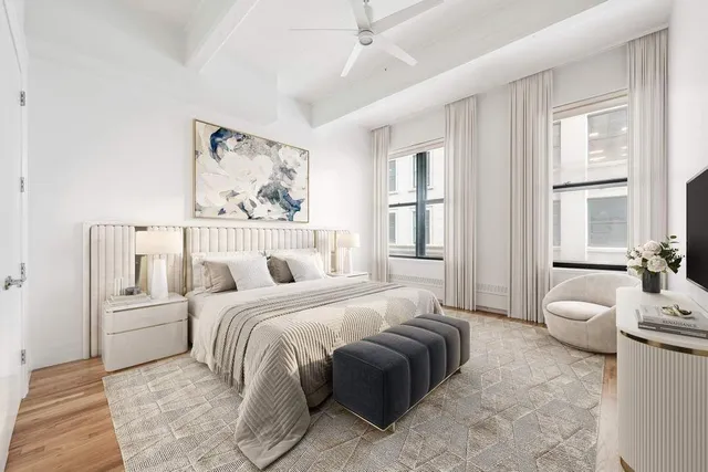 a spacious bedroom with a bed a couch and a window