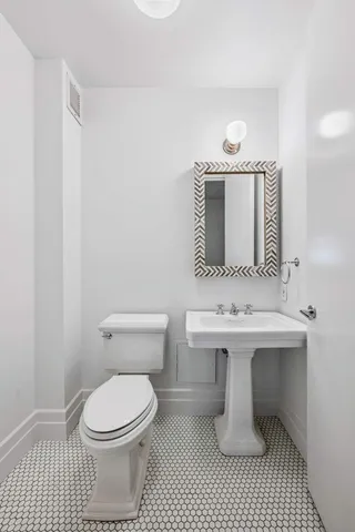a bathroom with a sink a toilet and mirror