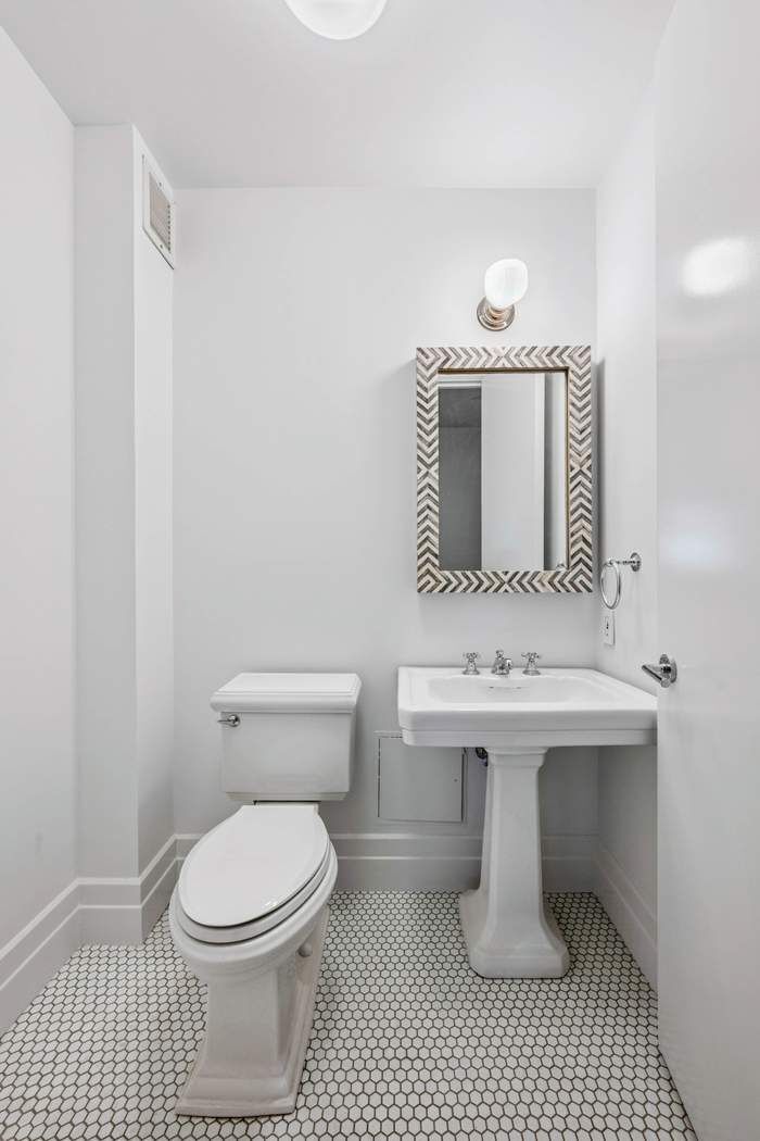 1 Main Street, Unit 2J Brooklyn, NY 11201 - Photo 17 of 23 a bathroom with a sink a toilet and mirror